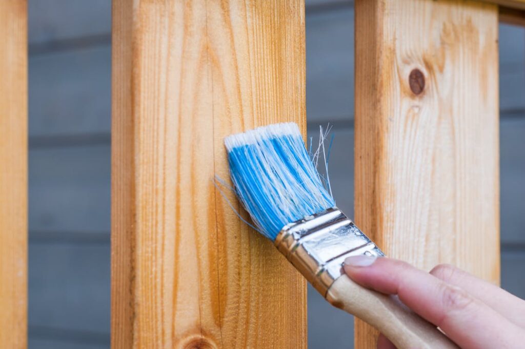 A person painting a wooden panel