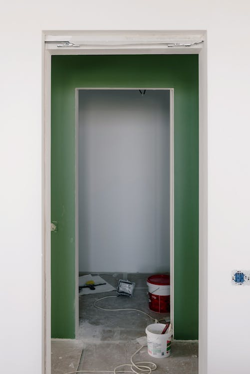 Empty apartment with painted wall during renovation process, highlighting the property repair and renovation efforts undertaken by homeowners.