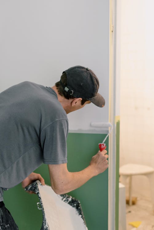 A person painting a wall of a house